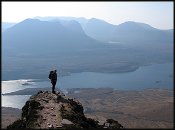 Dave on a pinnacle overlooking the rough hills of Coigach, with delightful little Beinn an Eoin in the foreground